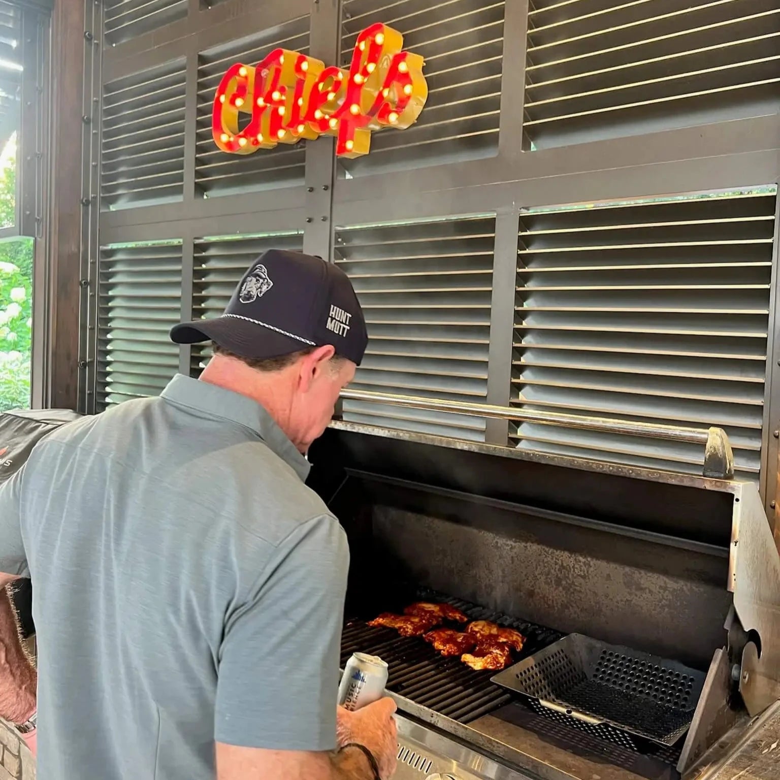 Hunting Life Man Wearing Hunt Mutt Top Rated Trucker Rope Hat Grilling Chicken BBQ 